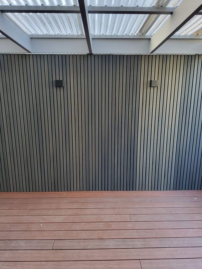 Smoke Grey composite cladding feature wall behind an outdoor dining area — Heidelberg