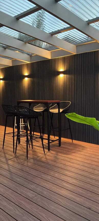 Kitchen bar zone at dusk — smoke grey cladding screen and wall sconces