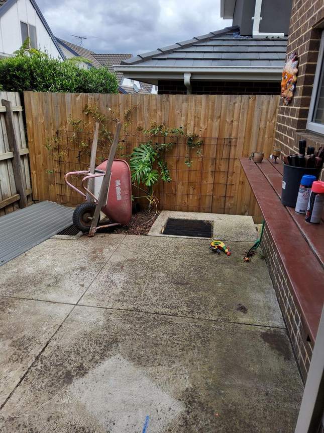 Kitchen end before — wheelbarrow and banana plant on concrete, Heidelberg