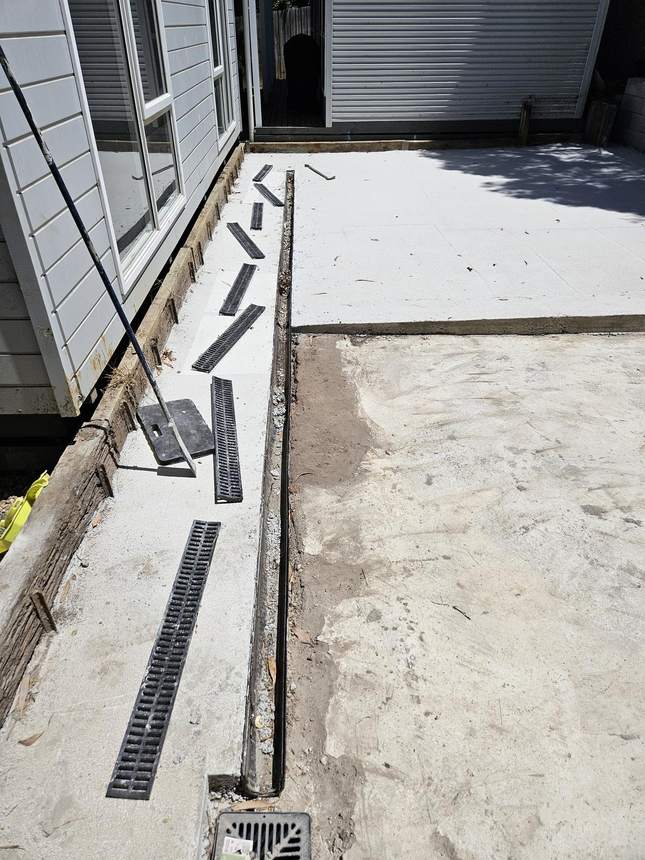 Rendered retaining wall face with drainage grilles installed at regular intervals