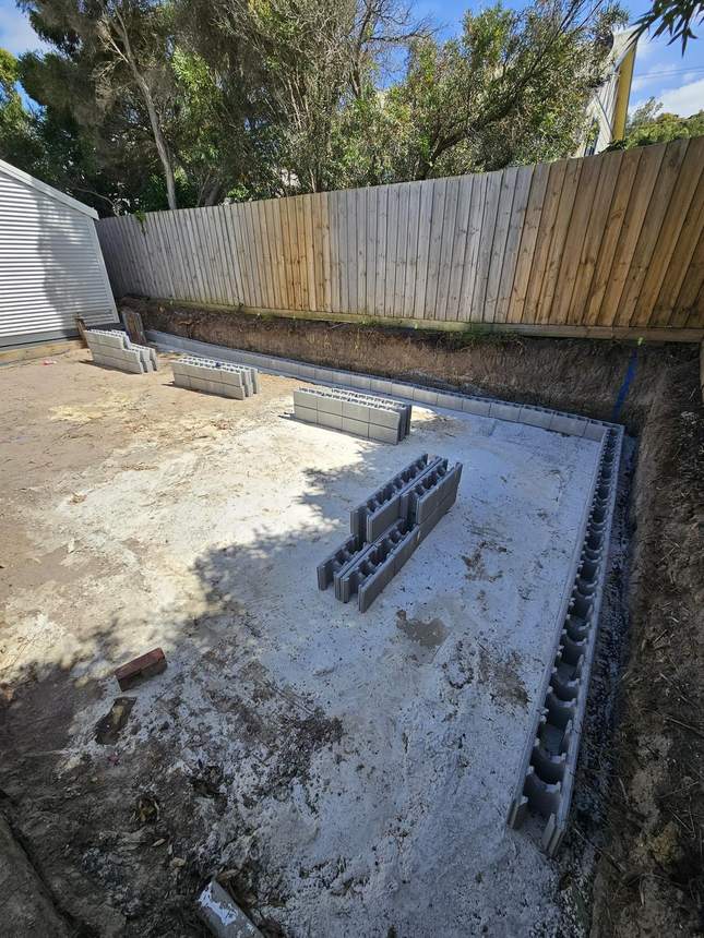 Concrete slab poured with first course of besser blocks going on