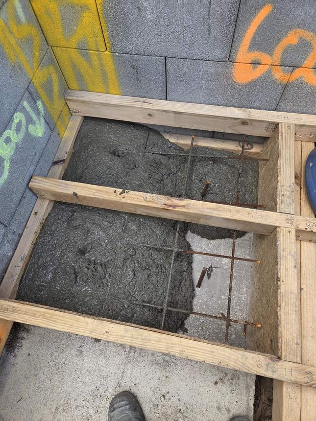 Concrete pergola footings being poured with reinforcing steel
