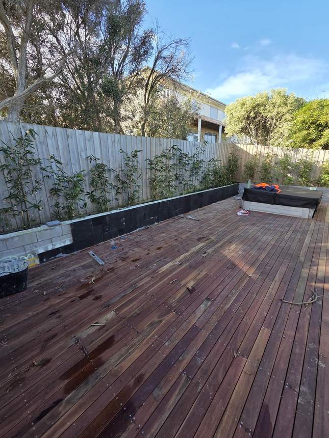Wider view of bluestone capping being laid on retaining wall top