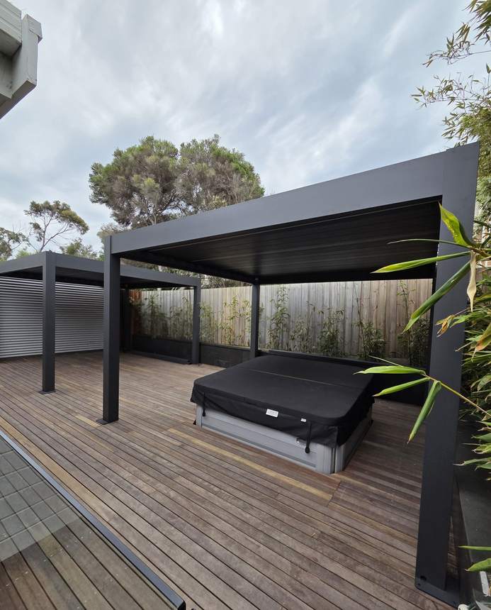 Full completed outdoor transformation — spa, deck, twin pergolas, bluestone and bamboo