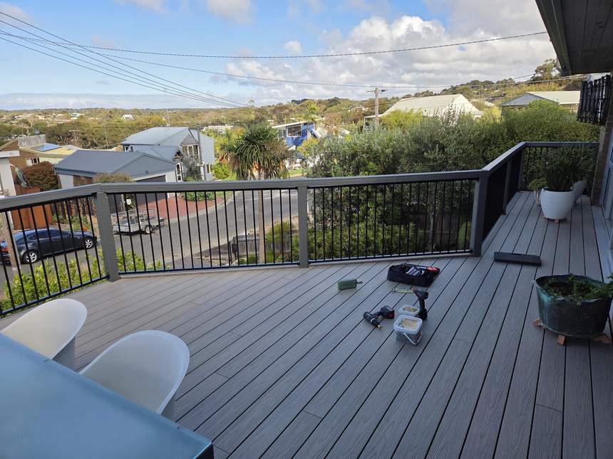 Composite deck with the new black aluminium frame balustrade installed along the edge, final items still on the deck — Jan Juc