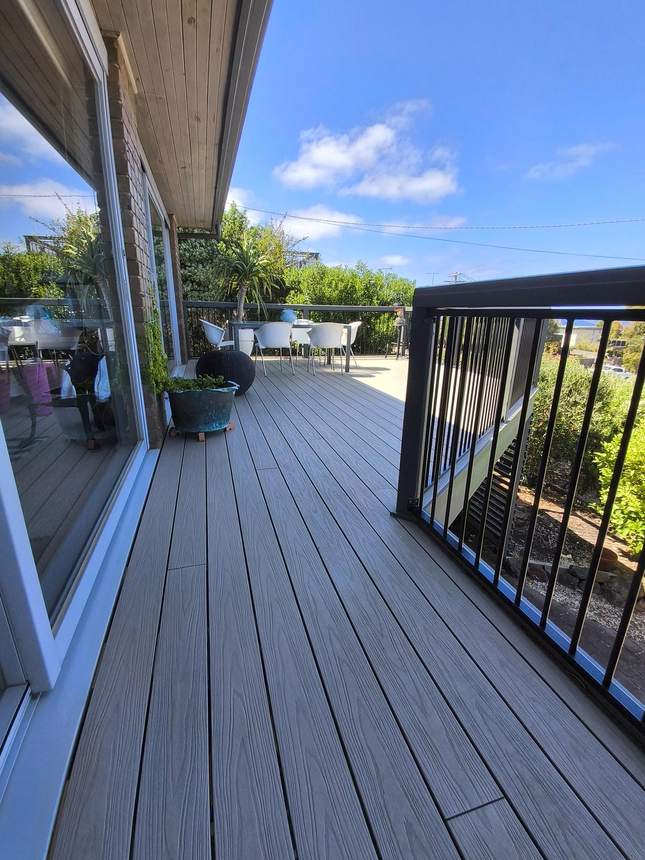 Completed Ash Grey composite deck with white outdoor furniture — Jan Juc