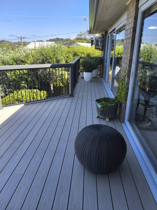 Finished deck detail — aluminium frame balustrade panel with rattan sphere ornament, Jan Juc