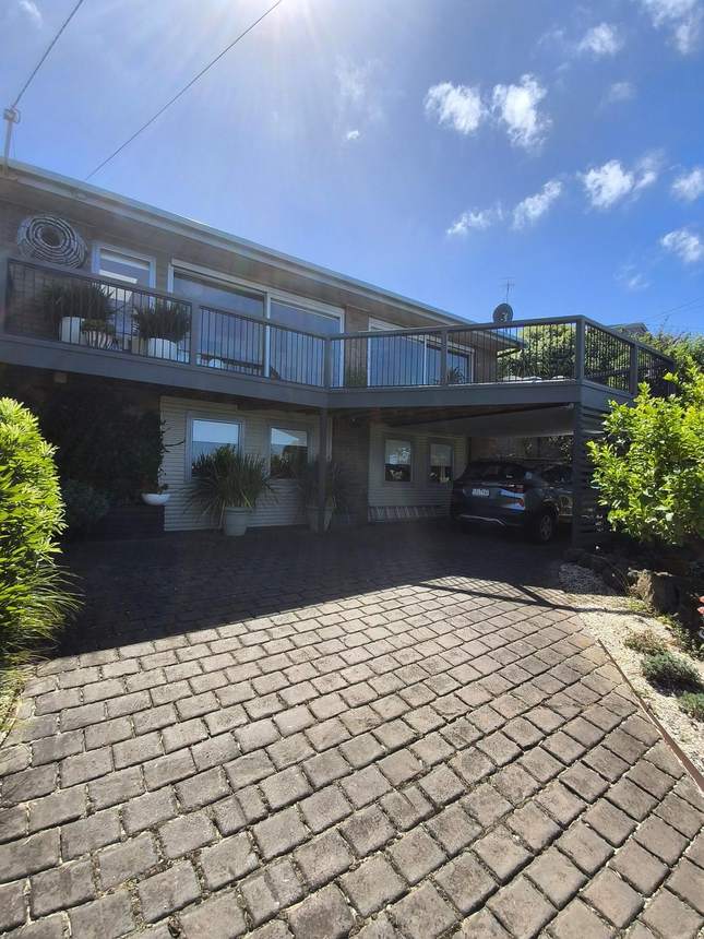 Exterior view of property from street showing elevated deck and balustrade — Jan Juc