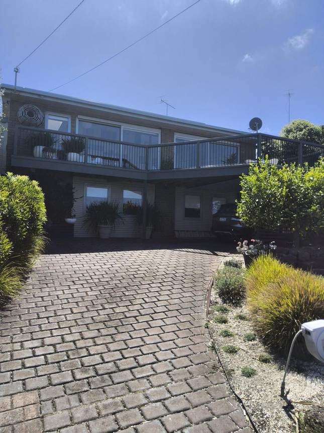 Exterior view of the property showing the elevated deck and aluminium frame balustrade above — Jan Juc