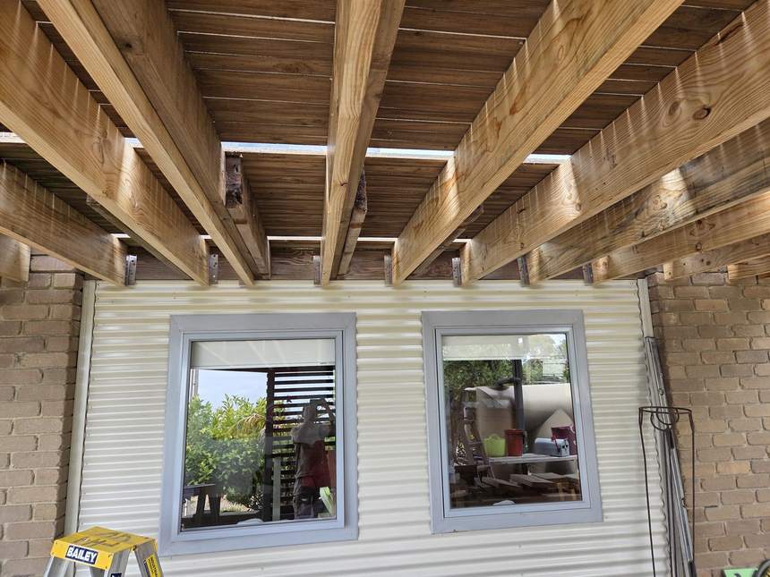 Rebuilt deck substructure seen from below — new bearers, laminated joists and saddle brackets, Jan Juc Surf Coast