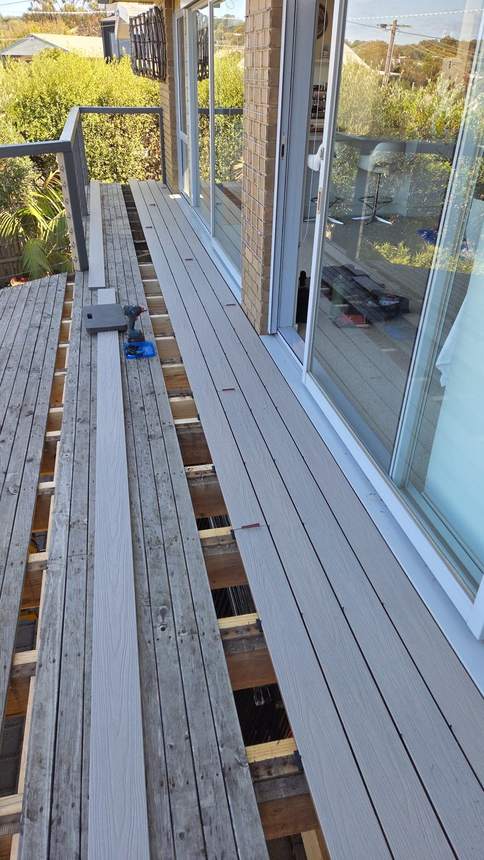 New Ash Grey composite boards laid in full runs beneath the glass roof — Jan Juc