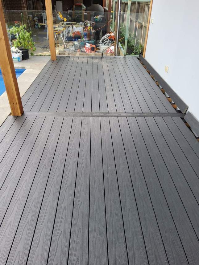 Dark charcoal composite boards running the full height of the pool-edge structure — Pakenham