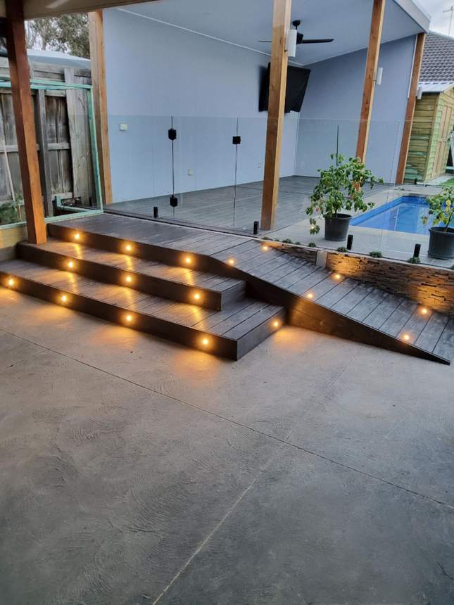 Completed pool-side composite deck with LED staircase and glass balustrade — Pakenham