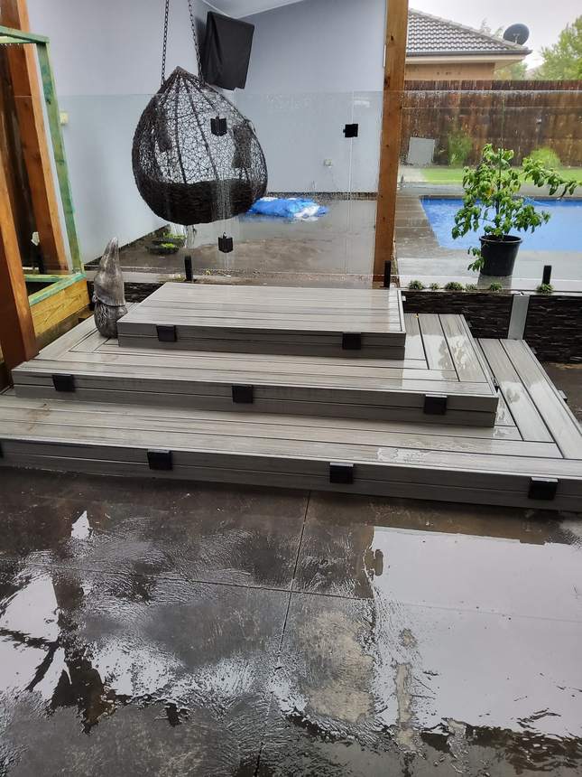 Old composite staircase with water pooling on paving below — the drainage problem visible, Pakenham