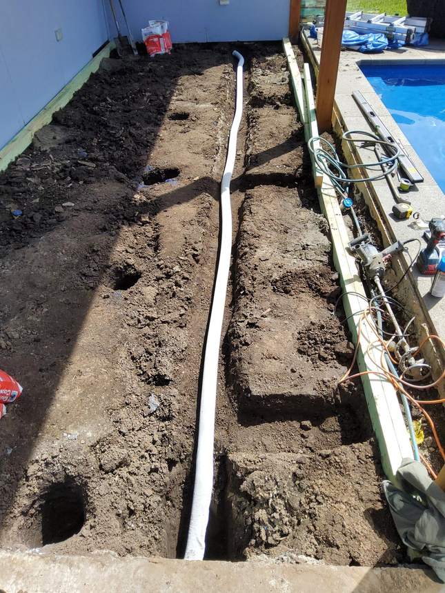 Horizontal agricultural drainage pipes installed in layers through excavated face — Pakenham