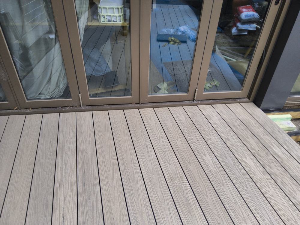Full-width composite board finishing against the black door frame