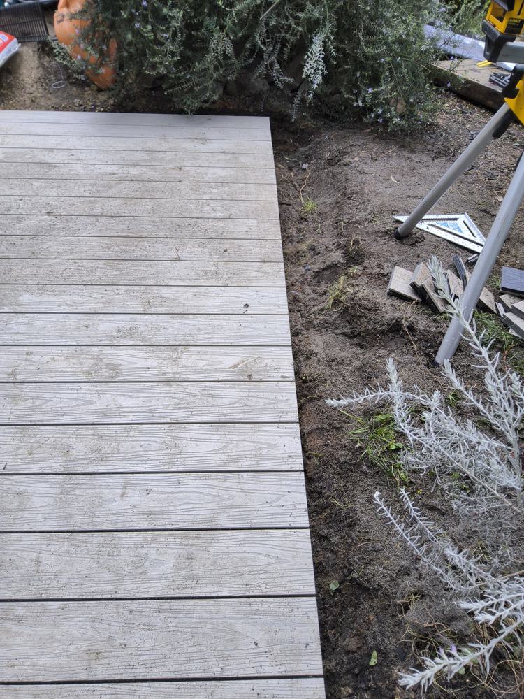 Composite board ends cut to one straight line at the garden edge