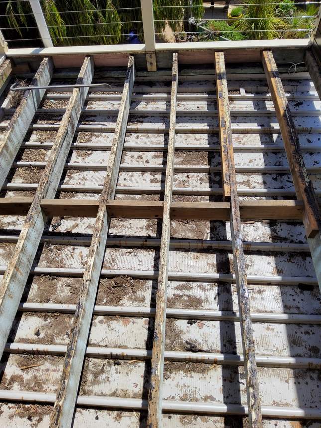 Old timber frame exposed — rotten, unbracketed and unprotected, a safety hazard — Seaford