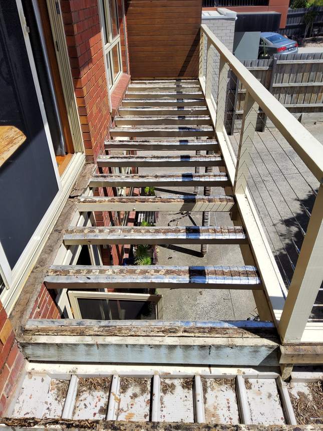 The old timber frame along its length — foil sarking over rotten, failing joists — Seaford