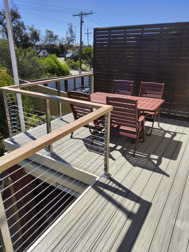 Completed deck — Beach composite, Tasmanian oak handrail, marine-grade wire — Seaford
