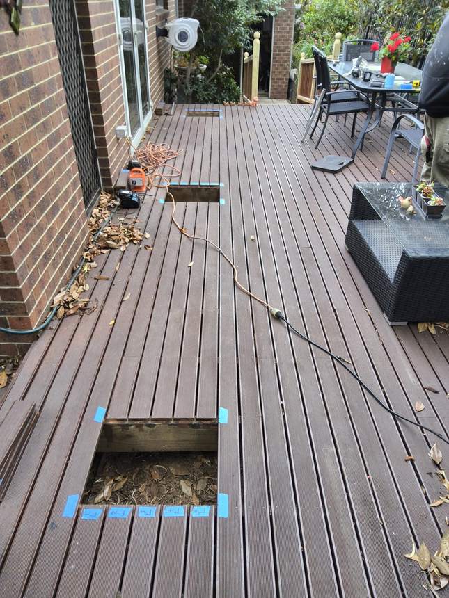 A footing opening cut through the deck boards down to the ground — Surrey Hills