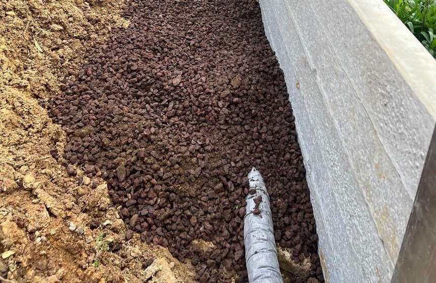 Scoria fill along the base of the wall with the agi drainage pipe exposed — Templestowe