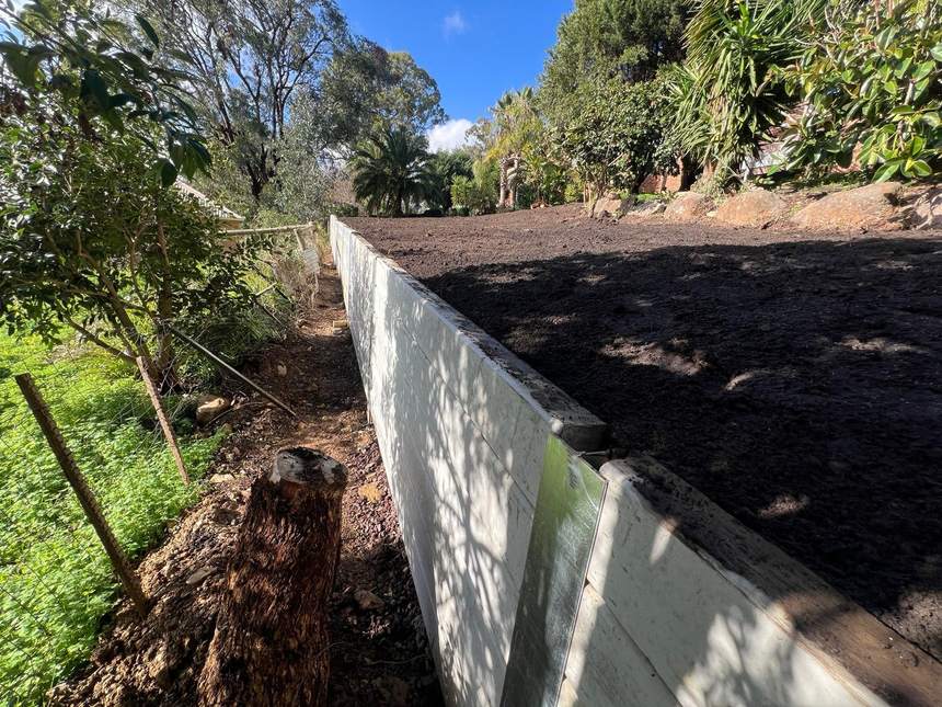 Finished retaining wall holding the bank with a level strip of yard reclaimed — Templestowe