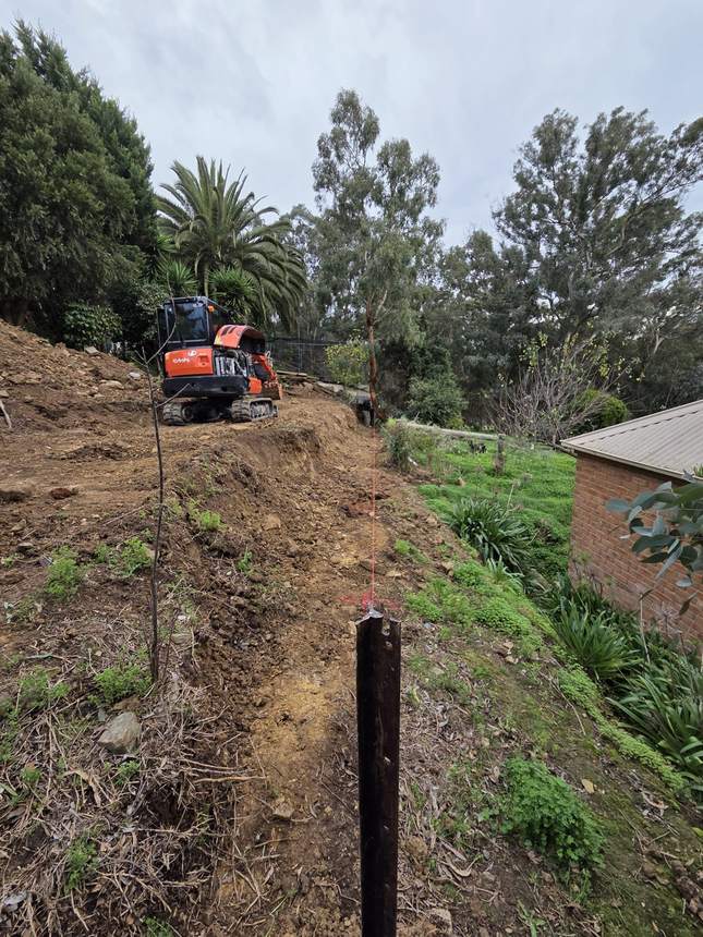 Excavator cutting the bank back during excavation — Templestowe