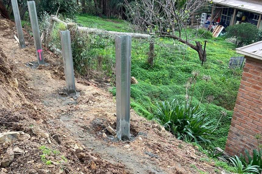 Steel posts concreted into the footings along the line of the wall — Templestowe