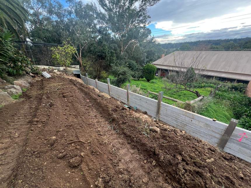 Completed 22.5m concrete sleeper retaining wall between steel posts — Templestowe