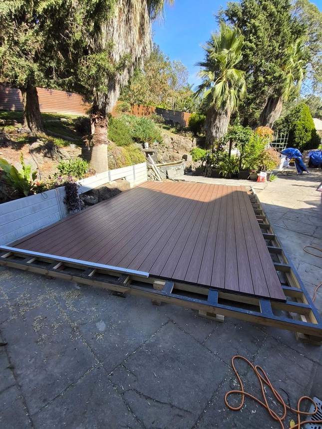 Boards positioned around retaining wall rock face — timber spacer, Templestowe